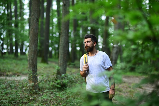 Wandelaar man wandelen in bos Mannelijke wandelaar wandelen in bos Wandelaar met rugzak wandelen in prachtig bos Kaukasisch mannelijk model buiten in de natuur