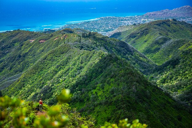 Foto wandelaar meisje staat op de top van wiliwiliniu ridge trail genietend van de skyline van oahu wandelen in hawaii