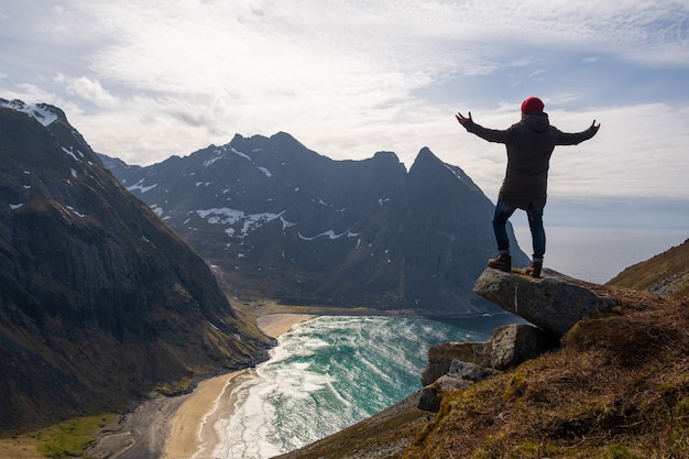 Wandelaar met rugzak die van zonsonderganglandschap geniet in Lofoten, Noorwegen