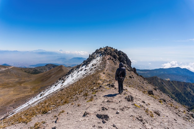 Wandelaar met rugzak ontspannen op de top van een berg