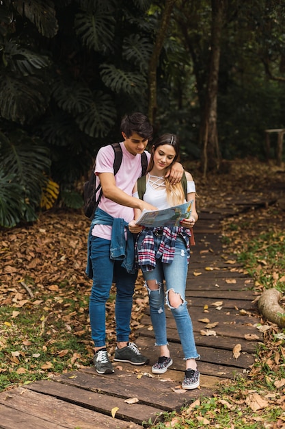 Wandelaarpaar kijkt naar een locatie op de kaart in de jungle