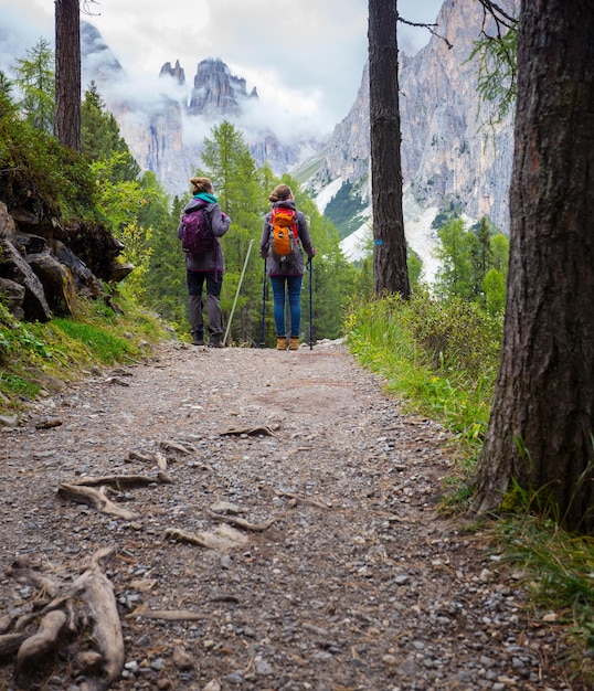 Wandelaarsmeisjes lopen langs het pad bij de tre cime di lavaredo. dolomieten, italië.