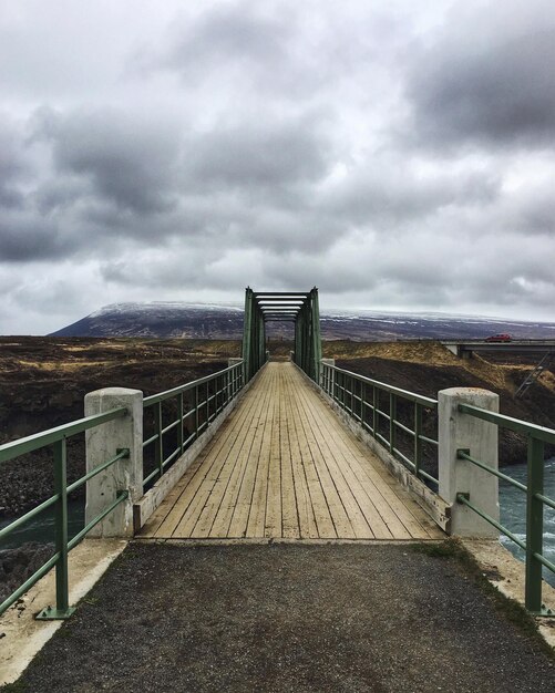 Foto wandelbrug over de zee tegen bewolkte lucht