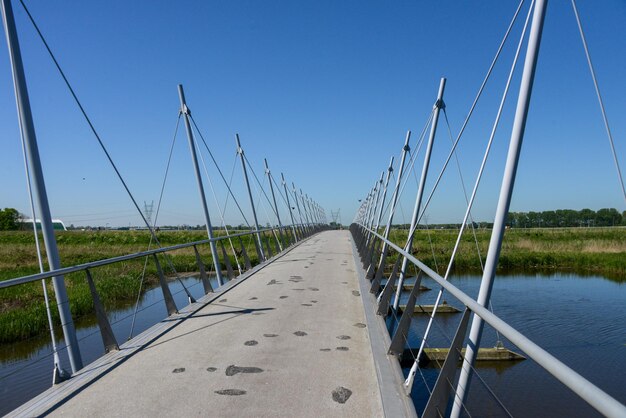 Foto wandelbrug over water tegen een heldere blauwe lucht