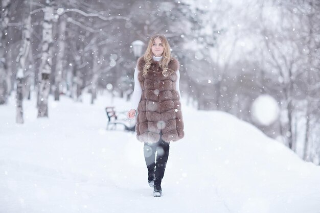 wandelen in een winterpark kerstmeisje / mooi model poseren in het winterseizoen wandelen stadspark