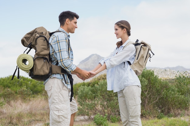 Wandelen paar hand in hand op berg terrein