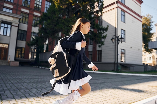 Wandelen Schoolmeisje is buiten in de buurt van schoolgebouw