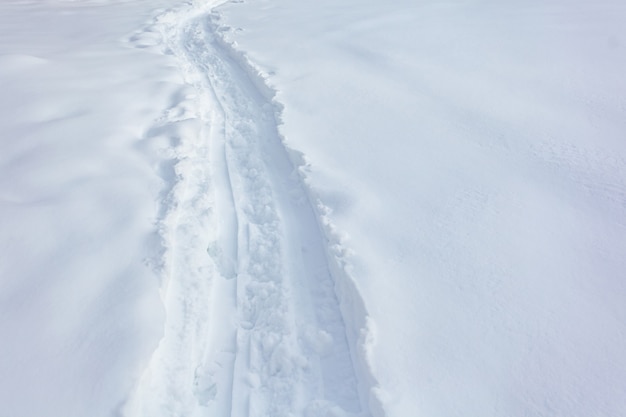 Wandelen volgt voetstappen in de verse sneeuw, winter