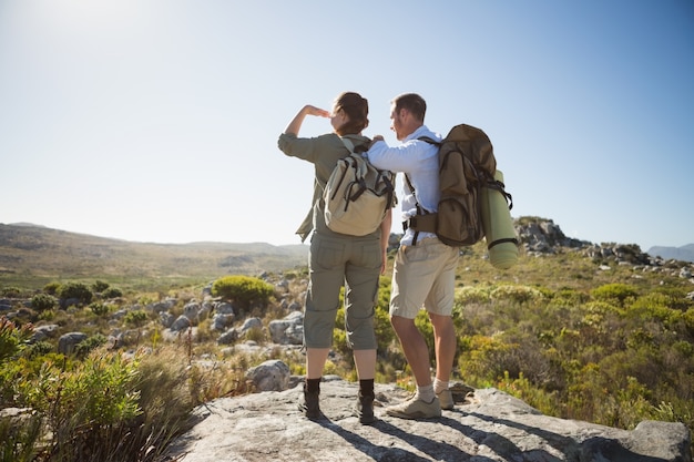 Wandelend paar die uit over landterrein kijken