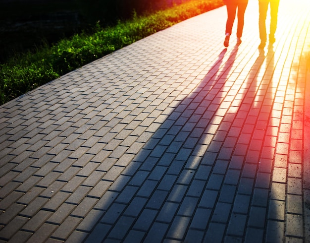 Wandelend paar in de bokehachtergrond van het zonsondergangpark hd