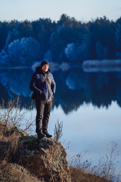 Wandelfotograaf bereidt zich voor op het maken van een foto van het ochtendlandschap in de herfstbergen Man kijkt met plezier naar de locatie