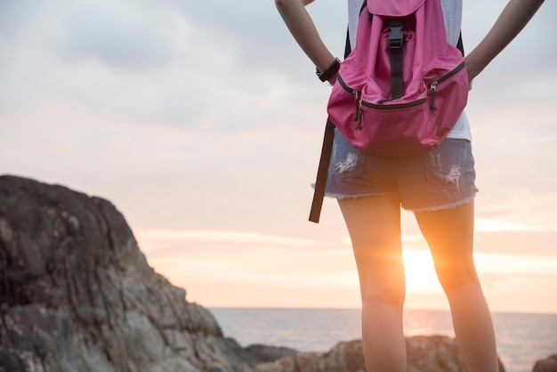 Wandeling backpacker meisjesreis op hoogste bergstrand tijdens zonsondergang