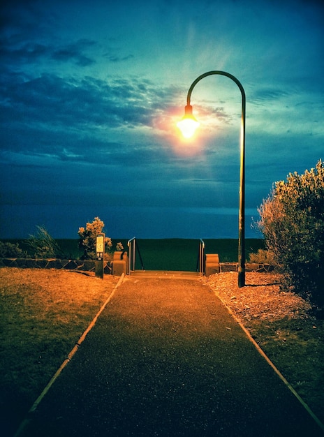 Foto wandelpad naar de zee tegen bewolkte lucht in de schemering