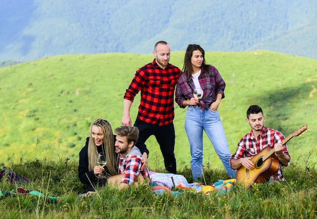 Wandelpicknick mensen eten eten jongeren die plezier hebben picknicken in de hooglanden vakantie vieren zomeravonturen wandelen met gitaar vrije tijd in de natuur groepsvrienden ontspannen picknick vrienden genieten van vakantie