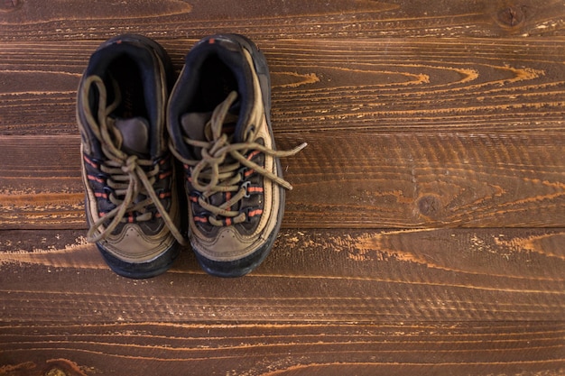 Wandelschoenen met topokaart en kompas op een houten ondergrond.