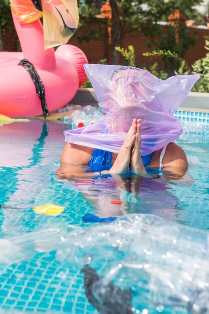 wanhopige hoopvolle man met een plastic zak over zijn hoofd in een vies zwembad.