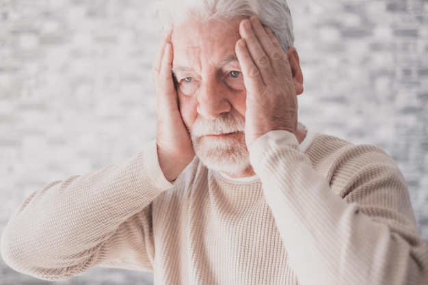 Wanhopige ongelukkige oude man met handen in het gezicht senior bebaarde man die lijdt aan echtscheidingsproblemen