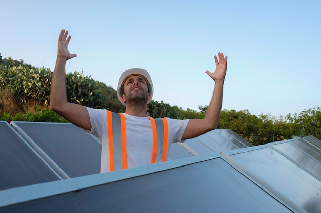 wanhopige zonnepaneelarbeider schreeuwt met zijn handen op zijn hoofd.