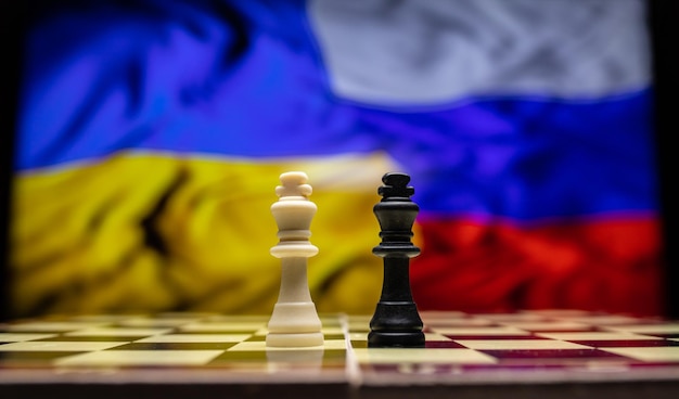 ロシアとウクライナの間の戦争チェス盤のピースと背景の国旗を使用した戦争の概念的なイメージウクライナのロシアの危機政治紛争2022年の戦争を止める