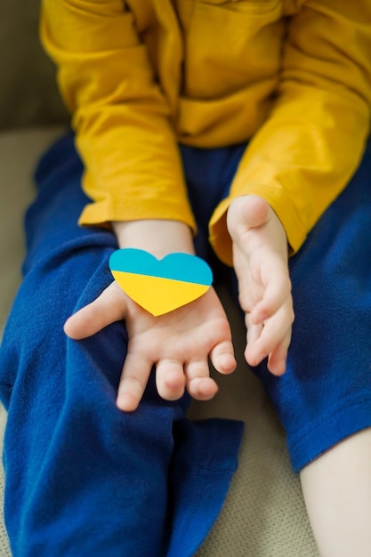 War in Ukraine The baby looks out the window with the flag of Ukraine