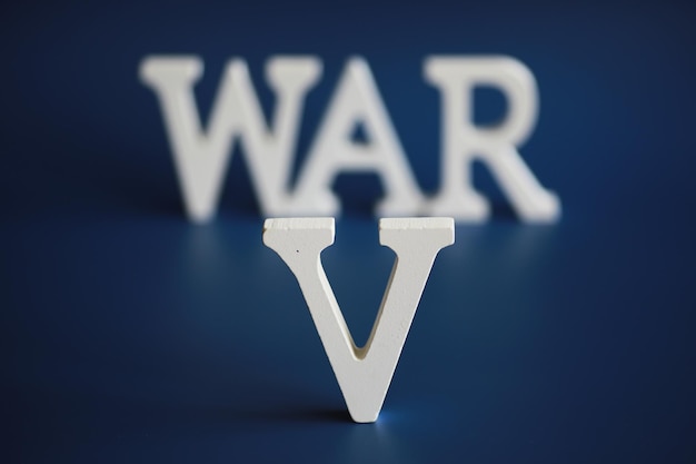 WAR word written in wooden alphabet letters on blue background The concept of a terrible war destroying country