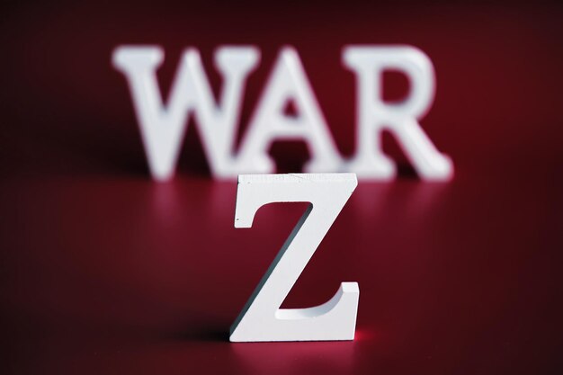 WAR word written in wooden alphabet letters on red background The concept of a terrible war destroying country