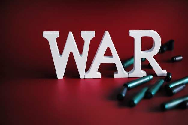 WAR word written in wooden alphabet letters on red background The concept of a terrible war destroying country