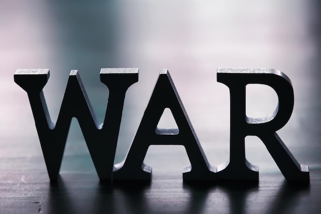 WAR word written in wooden alphabet letters on red background The concept of a terrible war destroying country