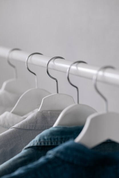 The Wardrobe clothes hanging on hangers stylish closet selection on a rail in the living room