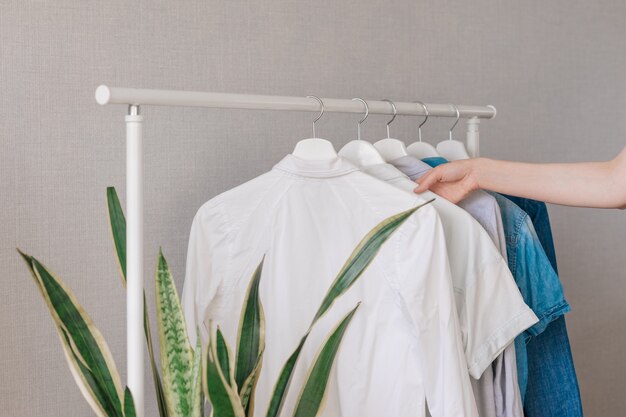 The Wardrobe clothes hanging on hangers stylish closet selection on a rail in the living room