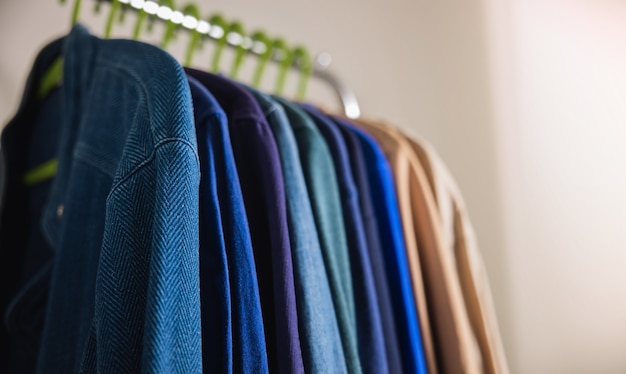 Wardrobe Rack. Men Clothes hanging on Bar by the White Wall. Fashion Lifestyle of a Stylish Man