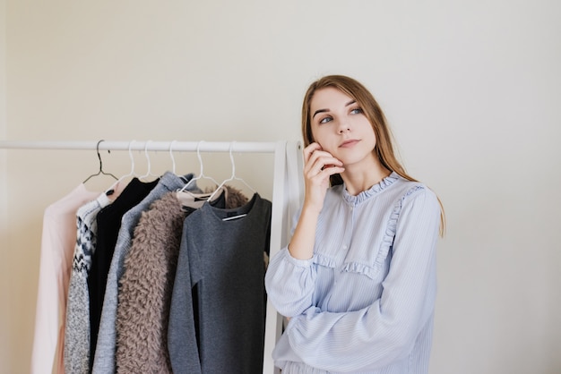 Wardrobe of a young girl. Dresses on hangers. Flour choice. What to wear? A girl in pajamas does not know what to wear.