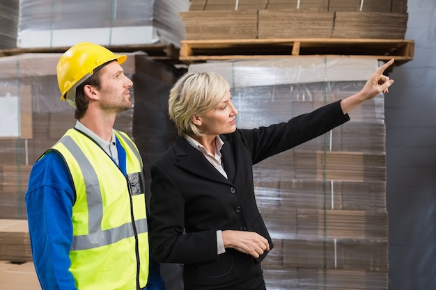 Warehouse manager pointing something to his colleagues