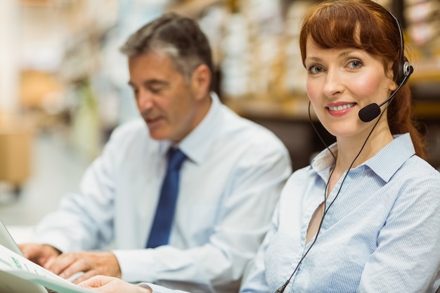 Warehouse manager working at her desk wearing headset