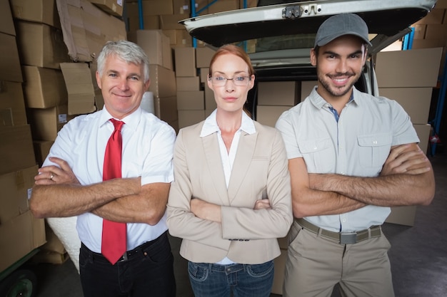 Warehouse managers and delivery driver smiling at camera