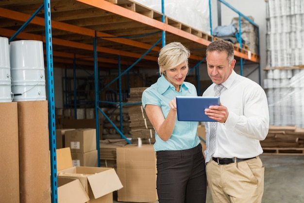 Warehouse managers looking at tablet pc