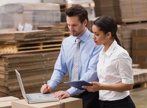 Warehouse managers working on laptop