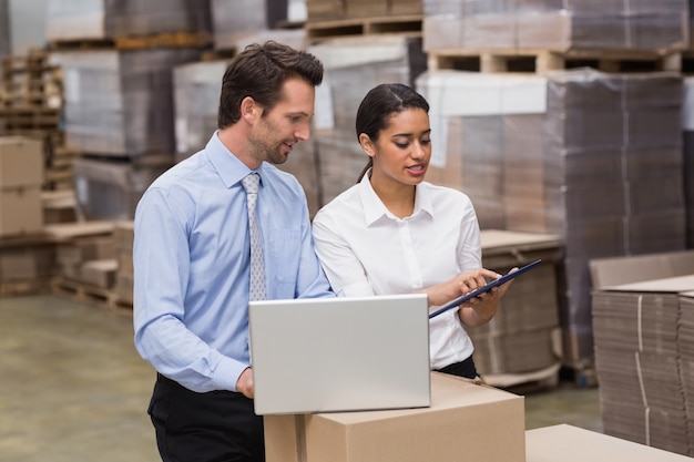 Warehouse managers working on laptop