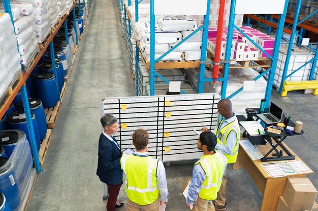 Foto warehouse personeel bespreken over whiteboard in het magazijn