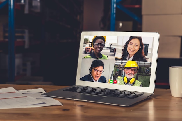 Warehouse staff talking on video call at computer screen in storage warehouse