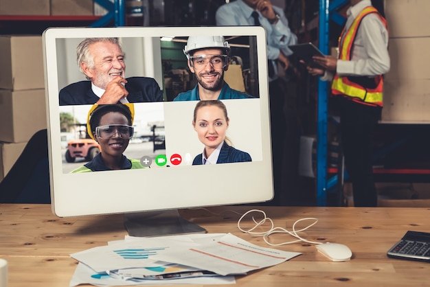 Photo warehouse staff talking on video call at computer screen in storage warehouse