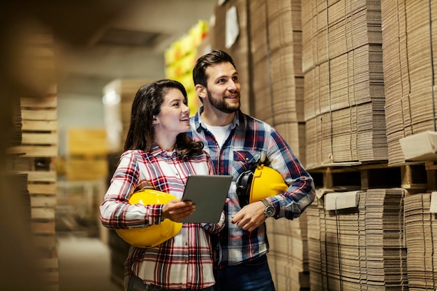 The warehouse supervisors checking on inventory and counting unfolded boxes in facility