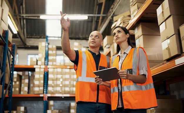 warehouse teamwork and employees pointing with tablet in factory for logistics and shipping