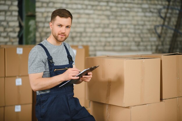 Warehouse worker carrying a carton for delivery to production stock