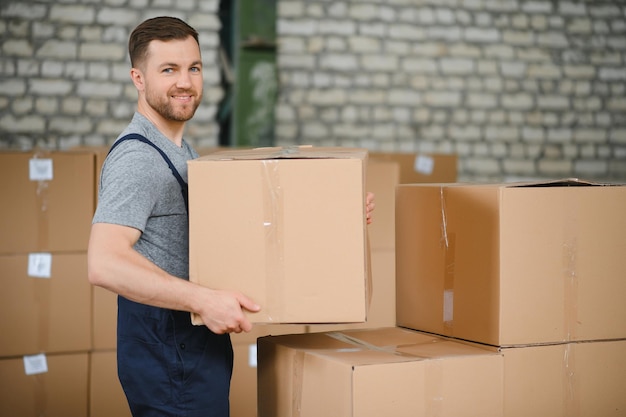 Warehouse worker carrying a carton for delivery to production stock