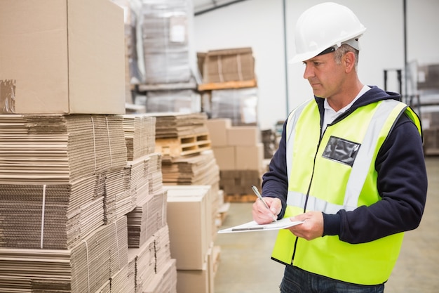 Warehouse worker checking his list on clipboard