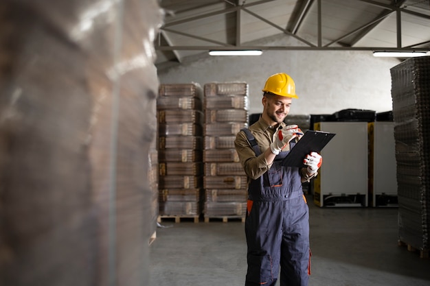 Warehouse worker controlling new palettes arriving in the storage.