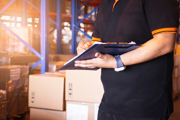 Warehouse Worker Hand Writing on Clipboard His Doing Inventory Management at Storage Warehouse