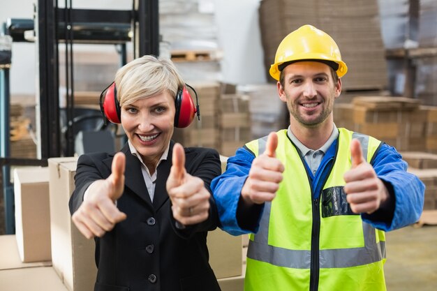 Warehouse worker and his manager giving thumbs up