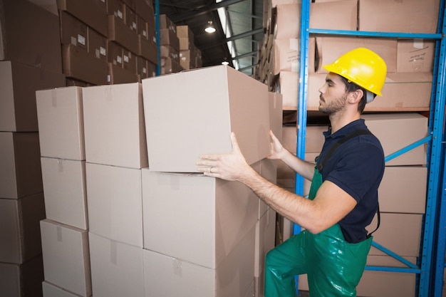 Warehouse worker loading up a pallet in a large warehouse